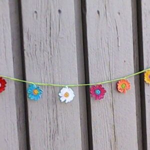 Gehäkelte Mini Girlande mit kleinen bunten Gänseblümchen